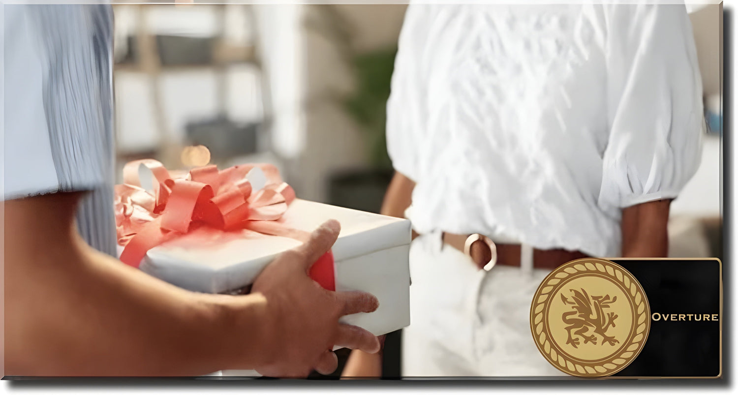 Person presenting gift box with red ribbon during birthday exchange