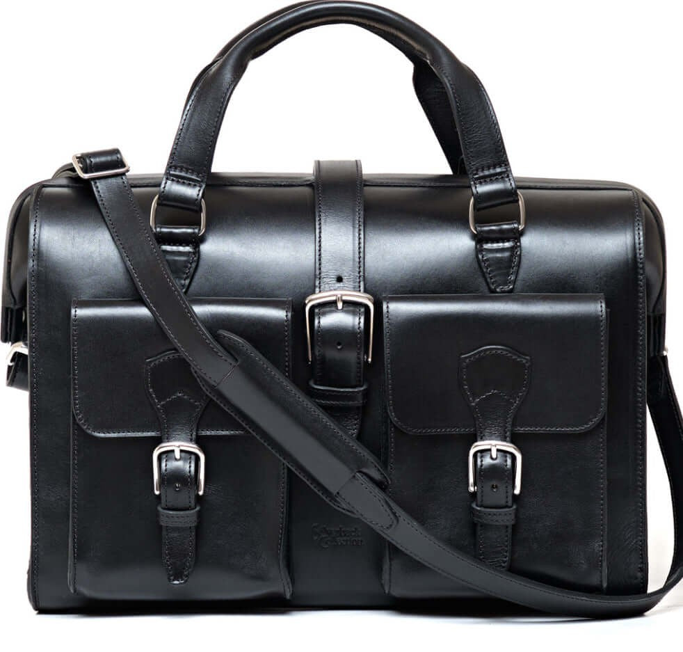 Black leather satchel bag with straps on a white background